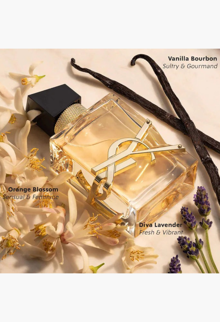 GLAM MODA perfume sampler set featuring a YSL Libre bottle surrounded by orange blossoms, vanilla beans, and lavender.