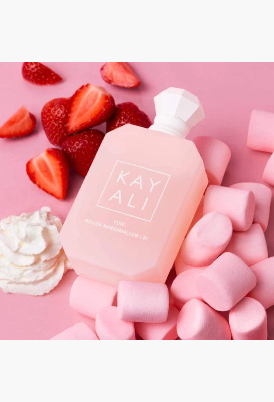 GLAM MODA Kayali Yum Boujee Marshmallow perfume bottle surrounded by fresh strawberries, whipped cream, and marshmallows.