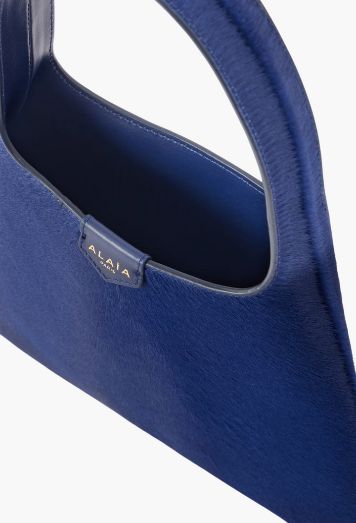 GLAM MODA Alaïa mini shoulder bag in deep blue calf hair with a slouchy open design and leather shoulder strap