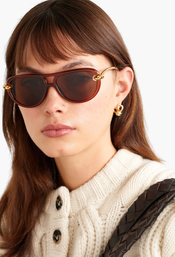 GLAM MODA New Knot aviator sunglasses with brown lenses and gold-tone twisted metal temples on a woman